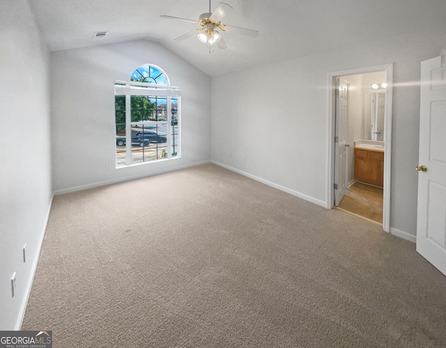 unfurnished bedroom with carpet, ceiling fan, lofted ceiling, and ensuite bathroom