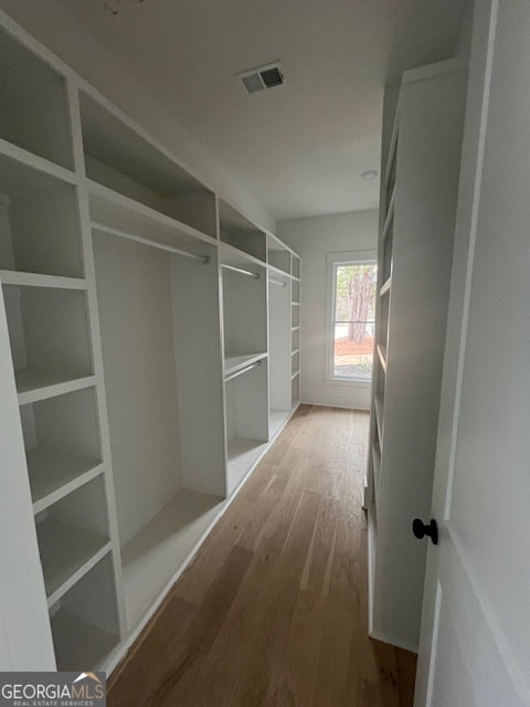 spacious closet with light hardwood / wood-style flooring