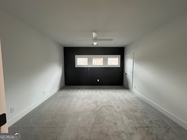 carpeted spare room with ceiling fan