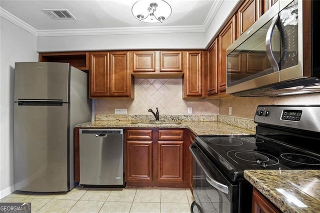 kitchen with ornamental molding, light stone counters, stainless steel appliances, and sink