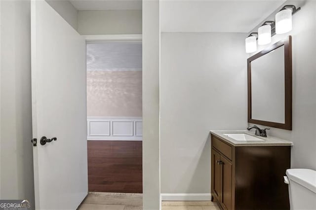 bathroom with hardwood / wood-style floors, toilet, and vanity