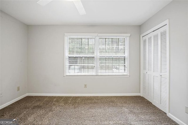 unfurnished bedroom featuring carpet flooring, ceiling fan, and a closet