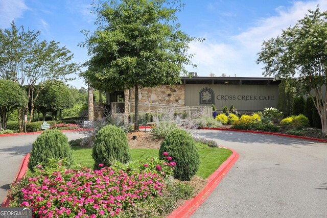 view of home's community with tennis court and a lawn