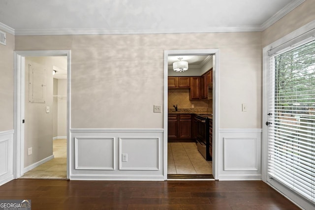 unfurnished dining area featuring ornamental molding, sink, and hardwood / wood-style flooring