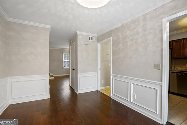 empty room featuring dark wood-type flooring and ornamental molding