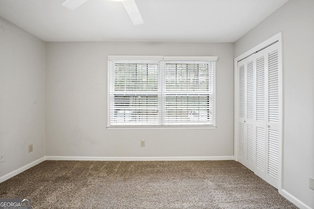 unfurnished bedroom featuring a closet, ceiling fan, and carpet