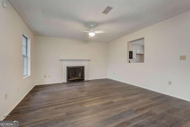 unfurnished living room featuring dark hardwood / wood-style flooring and ceiling fan