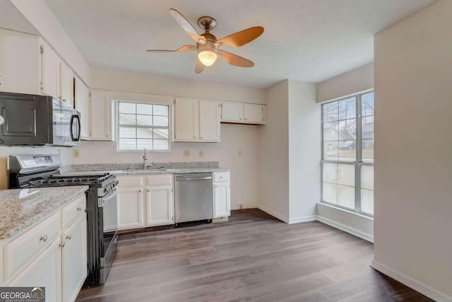 kitchen with ceiling fan, white cabinets, appliances with stainless steel finishes, dark wood-type flooring, and a wealth of natural light