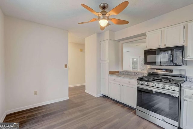 kitchen featuring ceiling fan, stainless steel gas range, white cabinets, and wood-type flooring