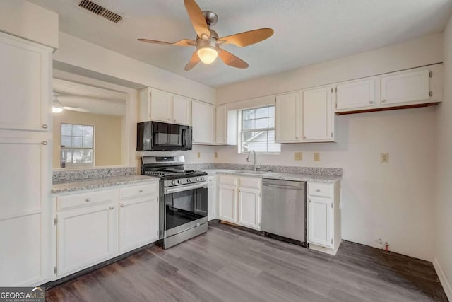 kitchen with white cabinets, ceiling fan, dark hardwood / wood-style floors, and stainless steel appliances