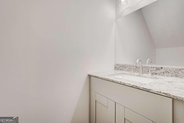 bathroom with vanity and vaulted ceiling