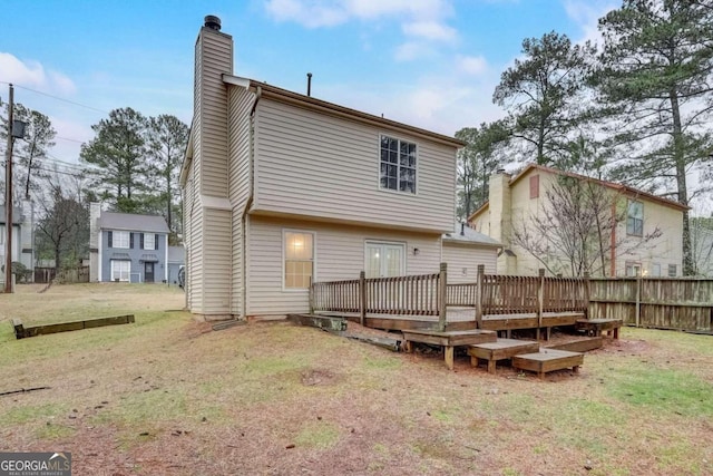 back of property featuring a lawn and a wooden deck