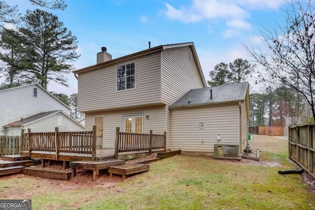 rear view of property with a wooden deck, central AC unit, and a yard