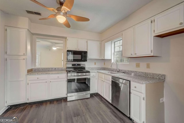 kitchen featuring stainless steel appliances, ceiling fan, sink, white cabinets, and dark hardwood / wood-style flooring