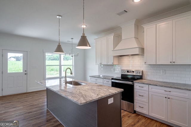 kitchen with custom exhaust hood, stainless steel electric range oven, a kitchen island with sink, white cabinets, and sink