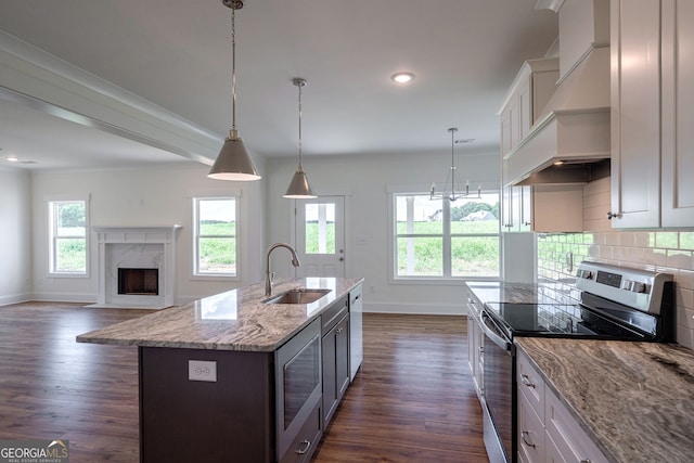 kitchen with a kitchen island with sink, sink, stainless steel appliances, and white cabinetry