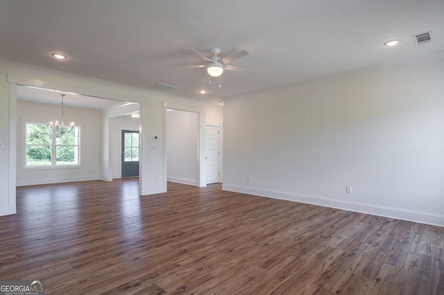 spare room featuring ceiling fan with notable chandelier, dark wood-type flooring, and crown molding