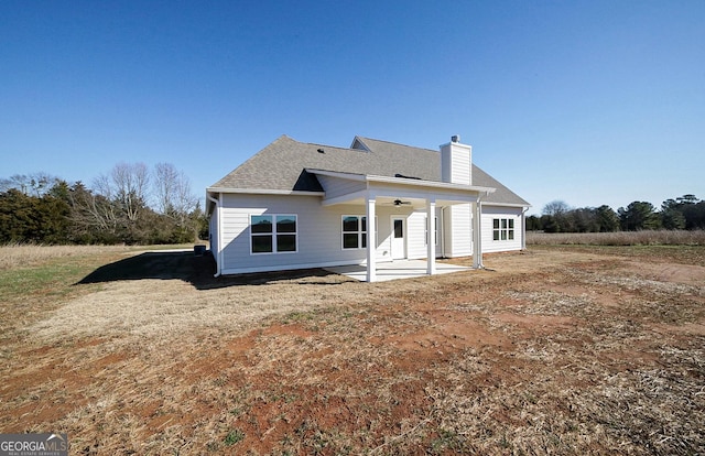 rear view of house with ceiling fan and a patio area