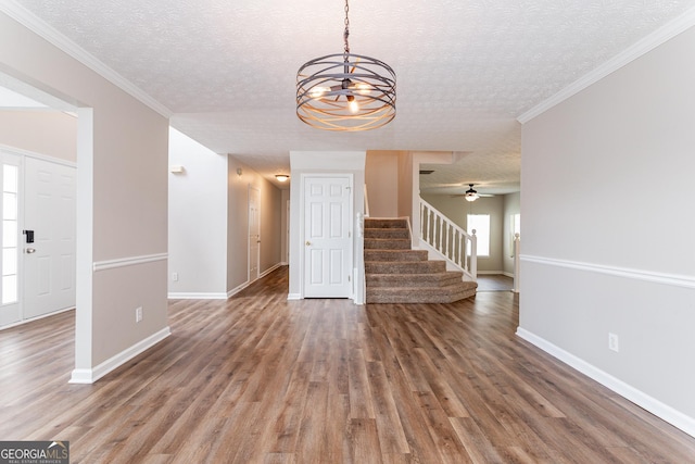 interior space with crown molding, wood-type flooring, and a textured ceiling