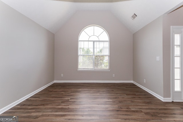 unfurnished room featuring vaulted ceiling, plenty of natural light, and dark hardwood / wood-style floors