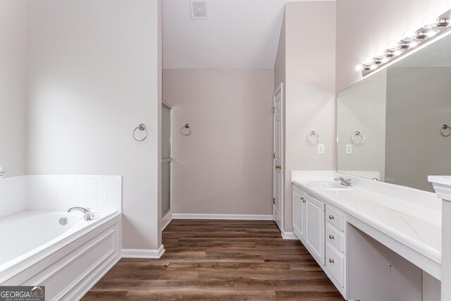 bathroom featuring hardwood / wood-style flooring, vanity, and shower with separate bathtub