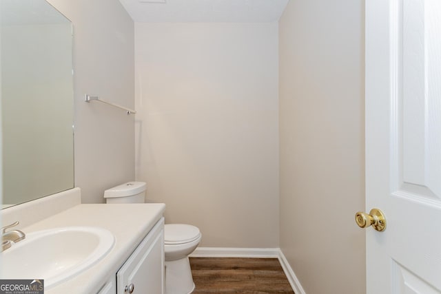 bathroom featuring vanity, wood-type flooring, and toilet