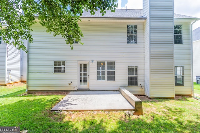 rear view of house with a patio and a yard