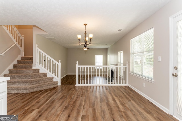 interior space featuring an inviting chandelier, hardwood / wood-style floors, and a textured ceiling