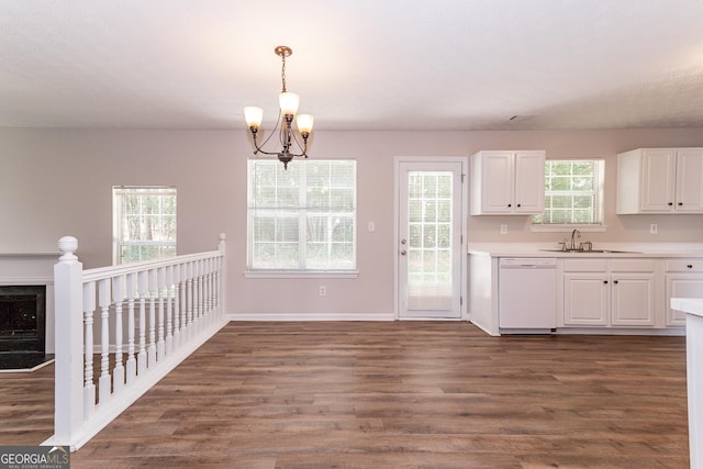 kitchen featuring white dishwasher, hanging light fixtures, dark wood-type flooring, and white cabinets