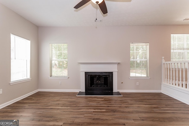 unfurnished living room with dark hardwood / wood-style floors and ceiling fan