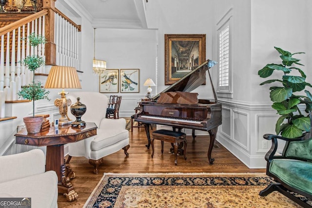 living area with crown molding and hardwood / wood-style floors