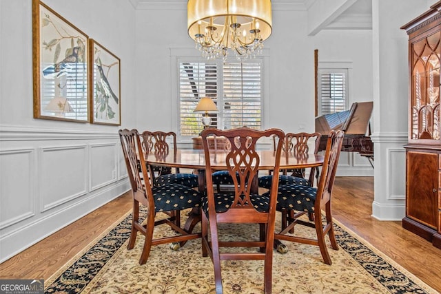 dining area with a chandelier, light hardwood / wood-style flooring, and crown molding