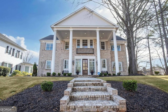 greek revival house with a front yard and a balcony