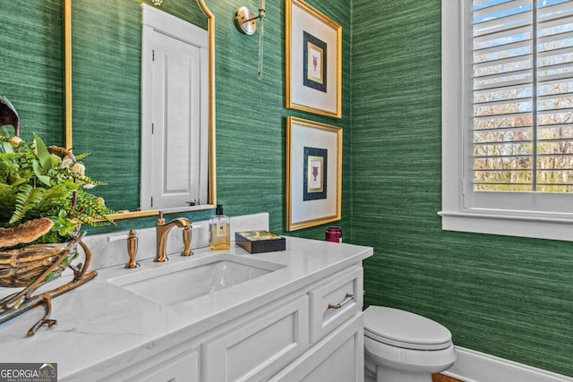 bathroom with vanity with extensive cabinet space and toilet