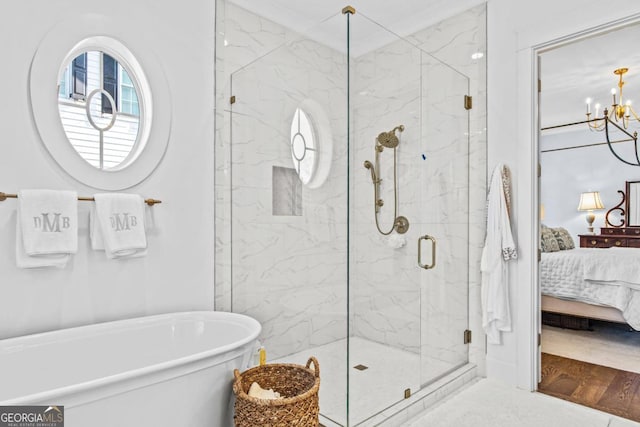 bathroom featuring a notable chandelier, hardwood / wood-style flooring, and plus walk in shower