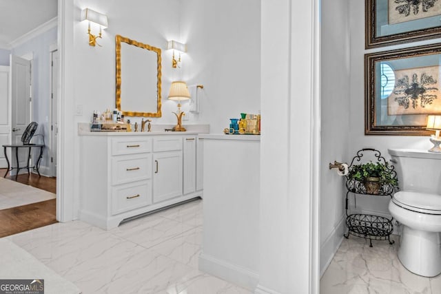 bathroom with tile flooring, ornamental molding, vanity, and toilet