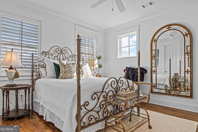 bedroom featuring dark hardwood / wood-style flooring, ornamental molding, and ceiling fan