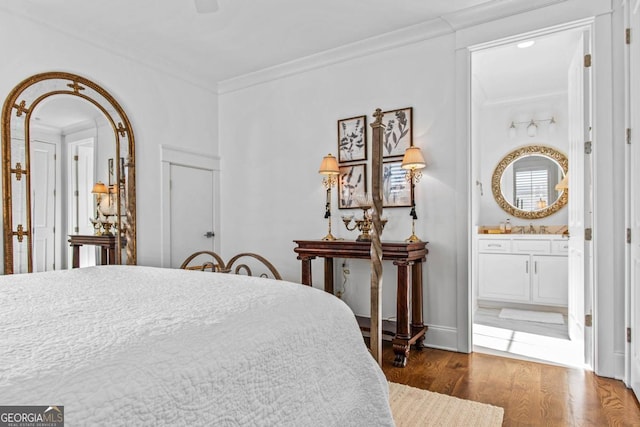 bedroom featuring sink, ornamental molding, dark hardwood / wood-style floors, and ensuite bath