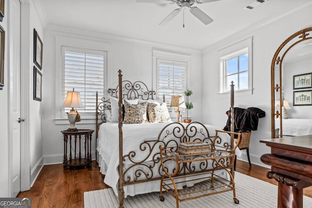 bedroom featuring crown molding, dark wood-type flooring, and ceiling fan