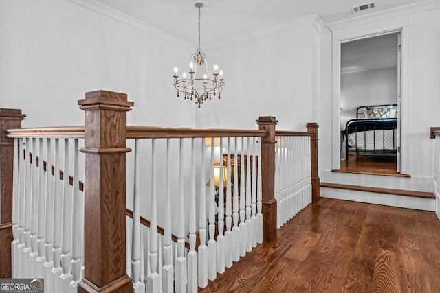 corridor featuring an inviting chandelier, dark hardwood / wood-style flooring, and ornamental molding