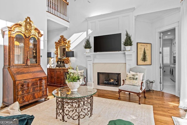 living room with a premium fireplace, independent washer and dryer, and wood-type flooring