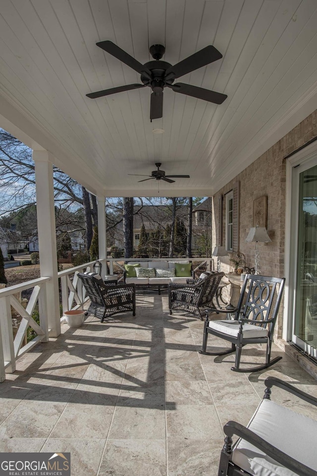 sunroom with ceiling fan and wooden ceiling