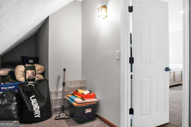 interior space featuring carpet flooring and vaulted ceiling