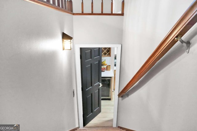 foyer entrance with a towering ceiling and light wood-type flooring