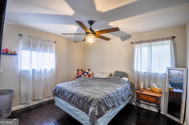 bedroom with dark hardwood / wood-style flooring and ceiling fan