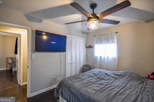 bedroom featuring dark hardwood / wood-style flooring, ceiling fan, and a closet