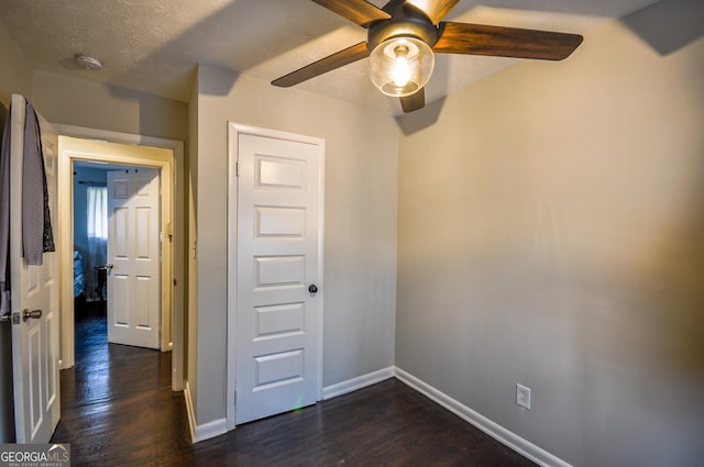 empty room featuring dark hardwood / wood-style flooring, ceiling fan, and a textured ceiling