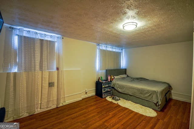 bedroom featuring a textured ceiling and dark wood-type flooring