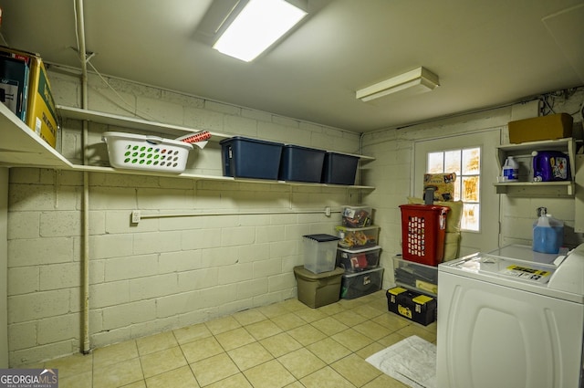 clothes washing area with light tile floors and washer / clothes dryer