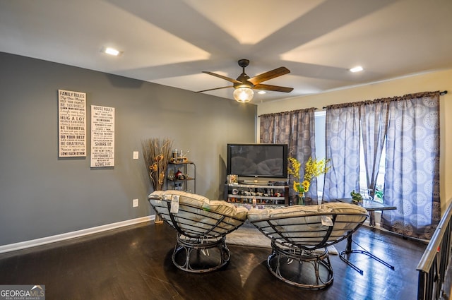 living area with a healthy amount of sunlight, ceiling fan, and dark hardwood / wood-style flooring